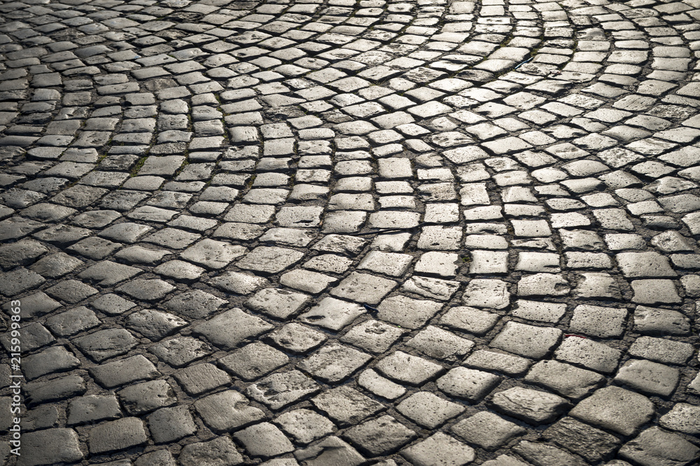 Full frame background of old-fashioned European cobbled plaza laid out in circular pattern in Naples, Italy