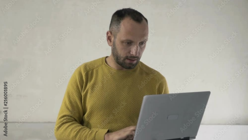 Young male architect with laptop looking around at new home
Young male architect with laptop looking around at new home