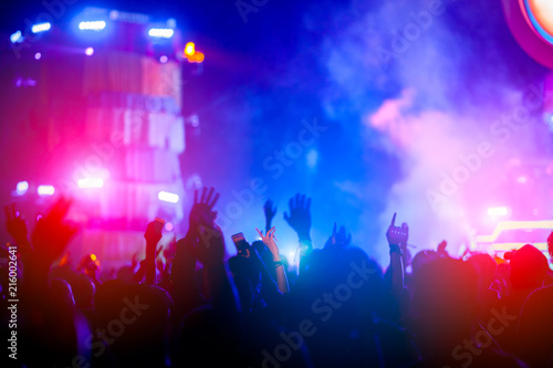 silhouettes of hand in concert.Light from the stage.