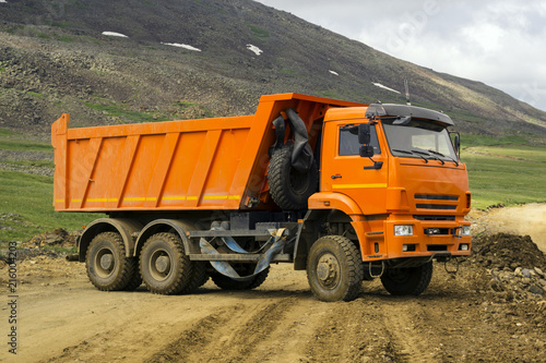 Photos dump truck turns on the mountain road under construction