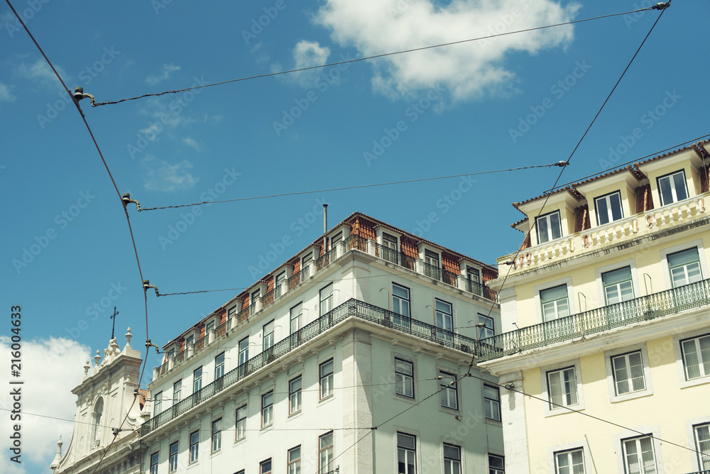Detalle minimalista de catenarias de tranvía junto a edificios