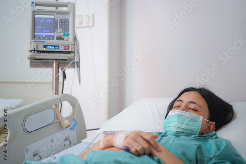 Close up young woman patient lay on bed in hospital with intravenous normal saline