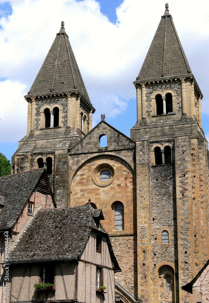 Facade and steeples of the abbey Sainte-Foy and medieval houses of the village of Conques, Aveyron, France
