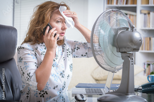Woman suffers from heat in the office or at home