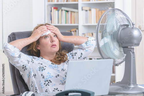 Woman suffers from heat in the office or at home photo