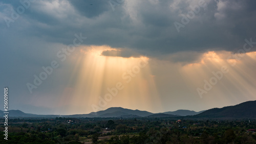 Rays of light shining through the clouds over mountains