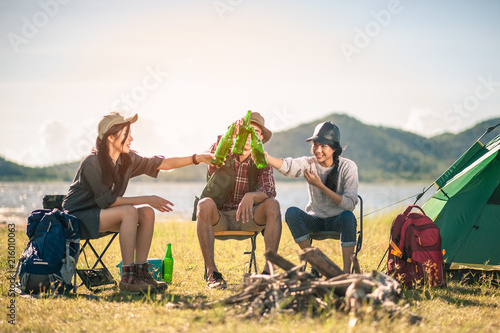  group of tourists clinking beer bottles in camping.adventure, travel, tourism, friendship and people concept.