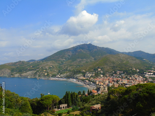 An amazing caption of the beautiful places from the 5 Terre in Liguria with an amazing blue sky and some green mountains in the background