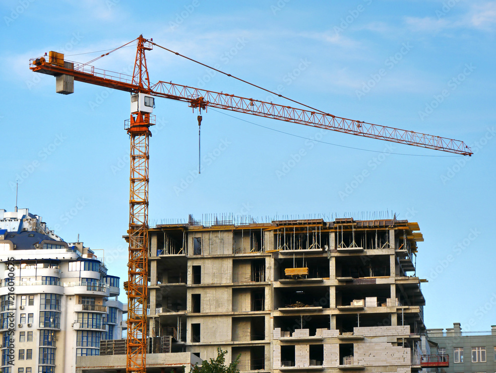 Construction site with crane and building. Crane and building under construction.