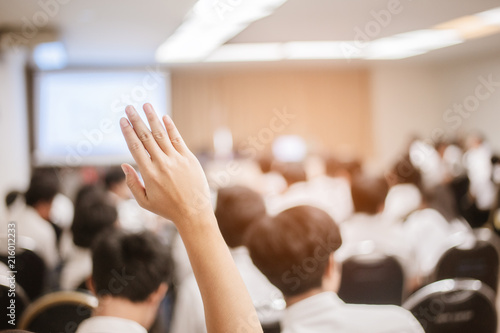  businessman raising hand during seminar. Businessman Raising Hand Up at a Conference to answer a question. photo