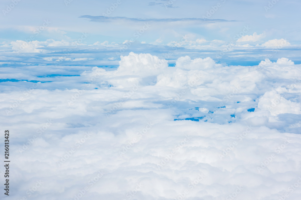 Fototapeta premium Aerial view of clouds and blue sky through airplane window