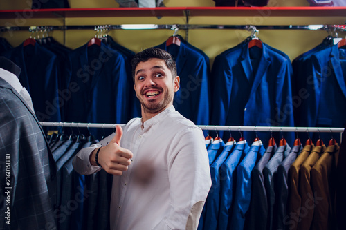 Tailor, tailoring. Men's suit, tailor in his workshop. Elegant man's suits hanging in row. Luxury mens classic suits on rack in elegant men's boutique. photo