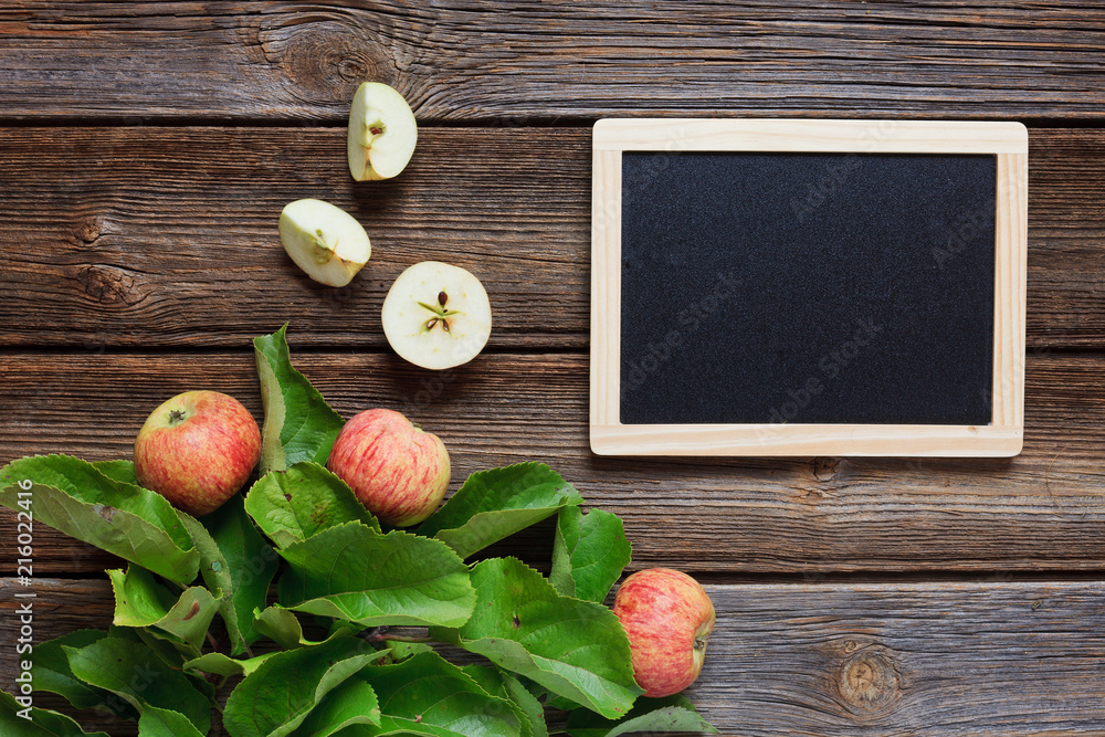 Φωτογραφία Fresh juicy apples on  branch with green leaves on wooden background in vintage stile