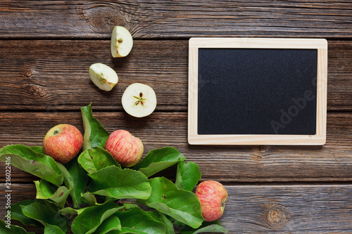 Fresh juicy apples on  branch with green leaves on wooden background in vintage stile.  Close-up  top view  space for your text