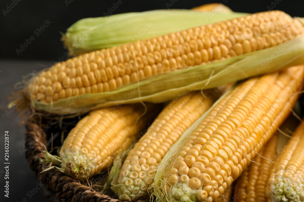Basket with tasty sweet corn cobs, closeup Basket with tasty sweet corn cobs, closeup