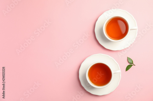Flat lay composition with delicious tea and green leaves on color background