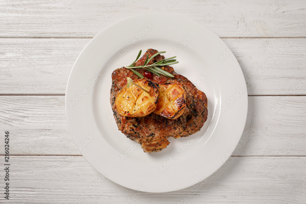 Plate with tasty grilled meat and potatoes on table, top view Plate with tasty grilled meat and potatoes on table, top view