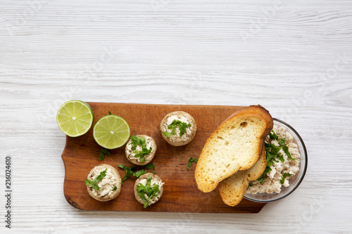Mushroom and chicken puree with lime and toasts on rustic wooden board, top view. White wooden background. Flat lay, overhead.