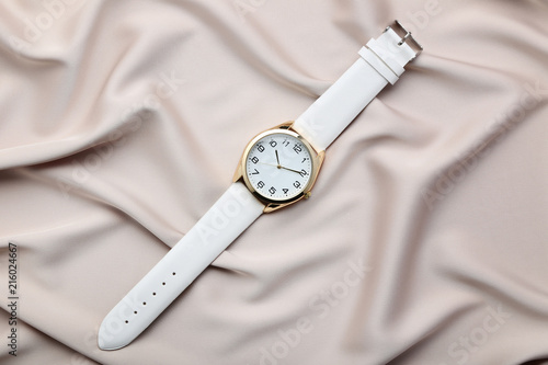 Wrist watch on beige satin background