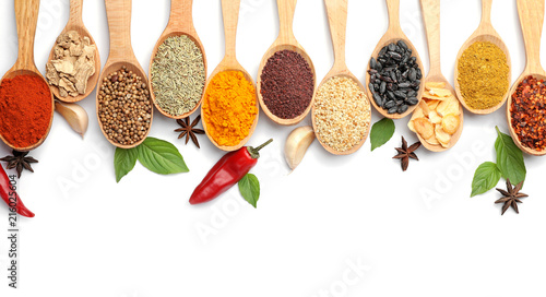 Composition with different aromatic spices in wooden spoons on white background