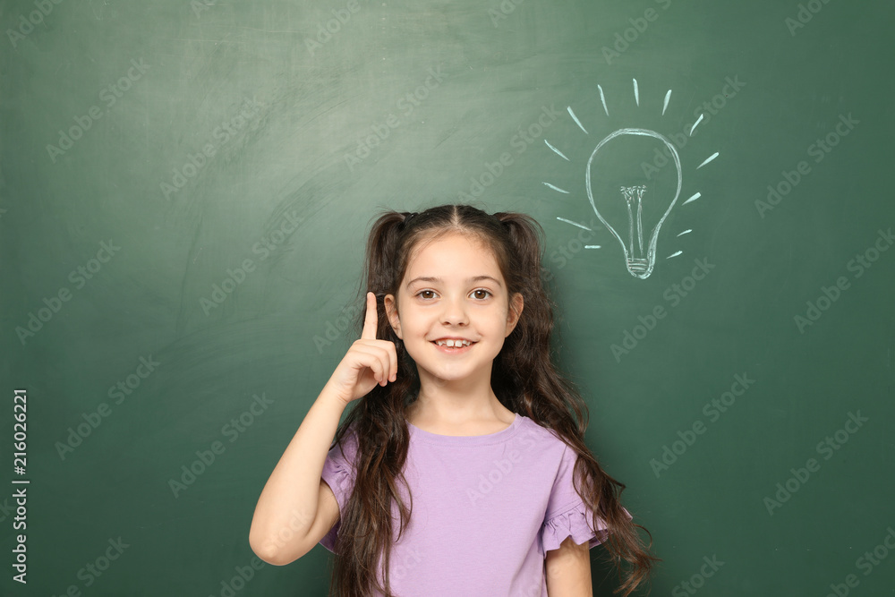 Little school child near chalkboard with lightbulb drawing Little school child near chalkboard with lightbulb drawing