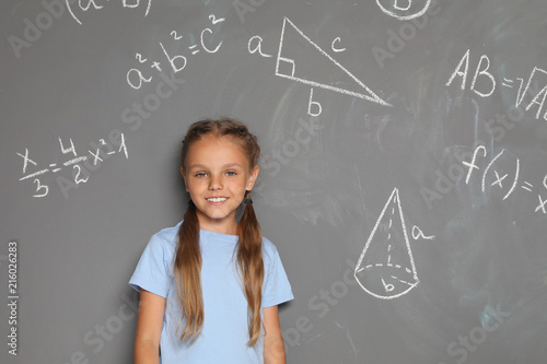 Little school child and mathematical formulas on grey background