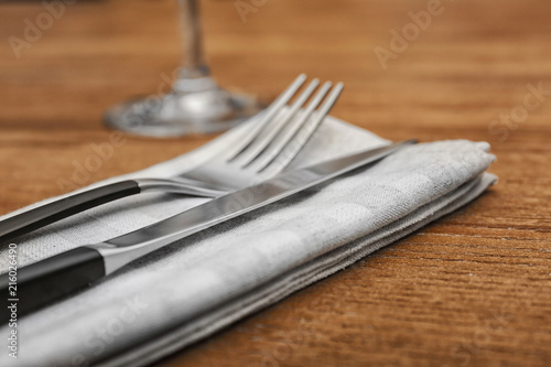 Cutlery and napkin on wooden background, close up view. Table setting