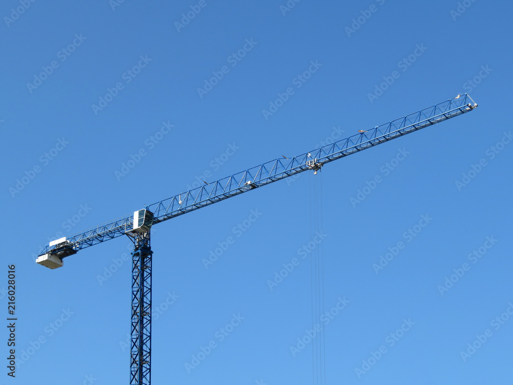 Construction crane isolated on background of clear blue sky. Building industry concept Construction crane isolated on background of clear blue sky. Building industry concept