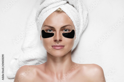 Obraz na płótnie cosmetic mask for the skin under the eyes. patch eye mask on a girl with a towel on her head w salonie