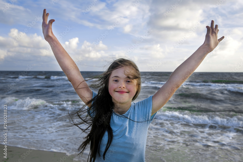 Portrait of down syndrome girl smiling on background of the sea Portrait of down syndrome girl smiling on background of the sea
