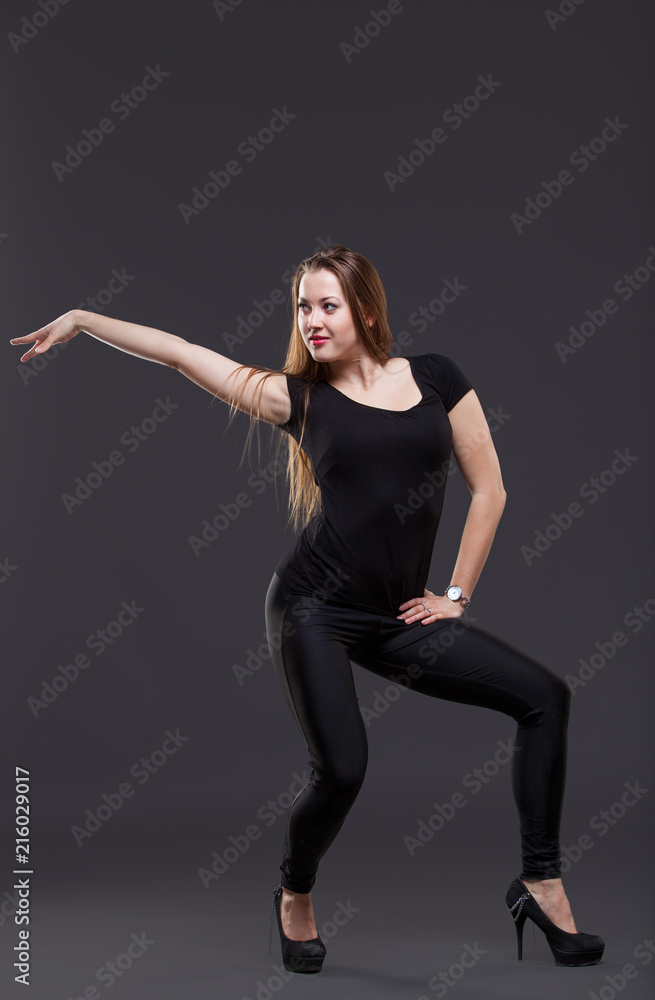 attractive young woman dancing, on a black background