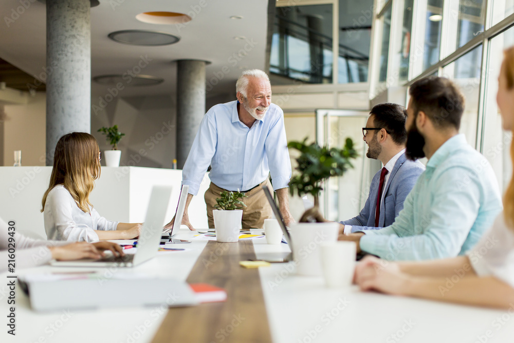 Senior boss holds a meeting for younger colleagues Senior boss holds a meeting for younger colleagues