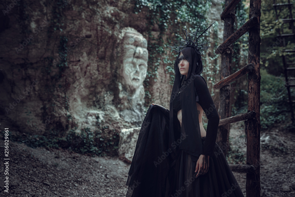 A woman is a prophet sorcerer and a preacher in a black mystical cloak