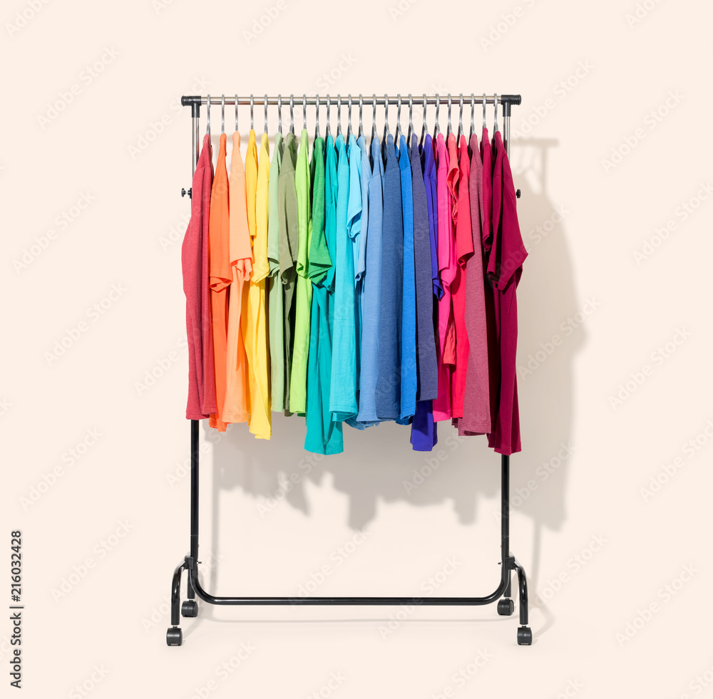 Mobile rack with color clothes on light background. File contains a path to isolation. 