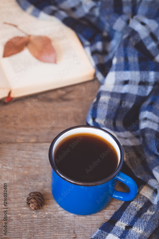 Blue cup of coffee with a knitted scarf on a wooden background Blue cup of coffee with a knitted scarf on a wooden background