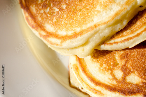 Freshly cooked pancakes on a white ceramic plate.