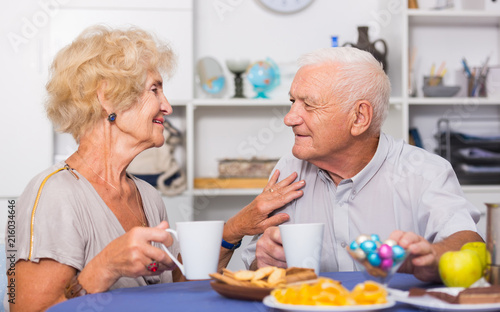 Happy senior couple enjoying conversation over cup of coffee