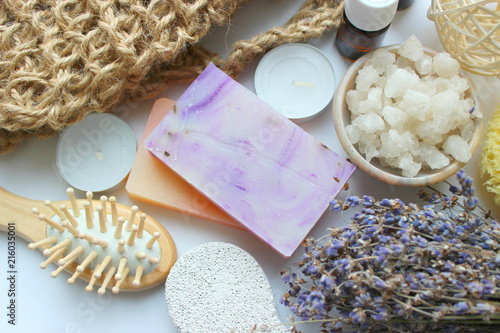 Spa accessories-sponge, natural soap, essential oil, pumice, salt, washcloth, comb, candles on a light background, top view. The concept of a healthy lifestyle. Beauty, skin care. flat position photo