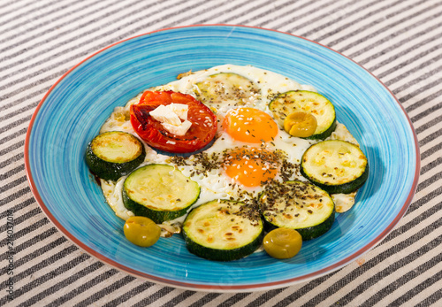 Image of fried eggs with zucchini and tomato