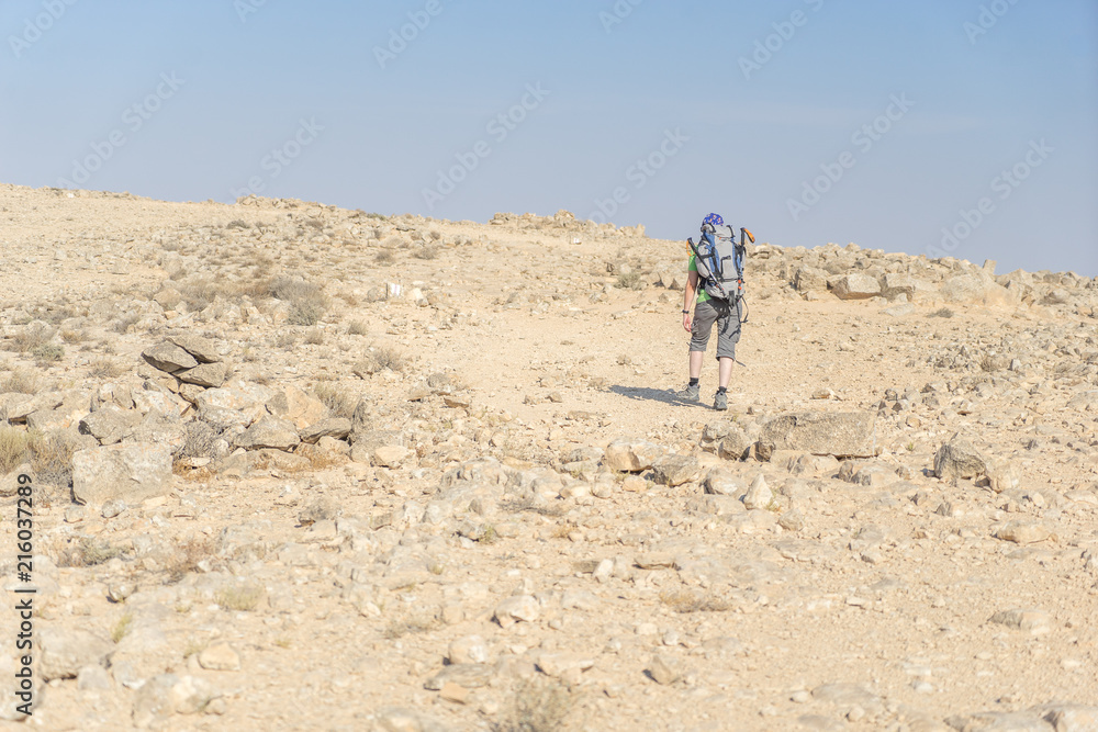 Hiking tourist in desert trek adventure