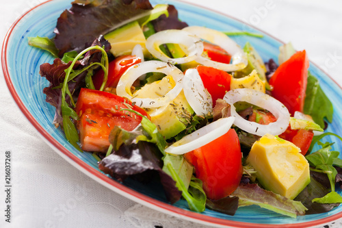 Salad with arugula, green avocado, tomato and  onion