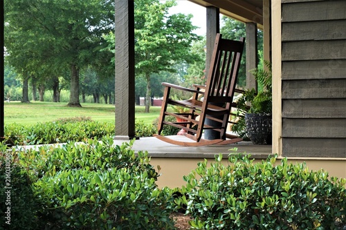 A wooden rocking chair on the beautiful terrace view is waiting for someone to relax on. Ga USA