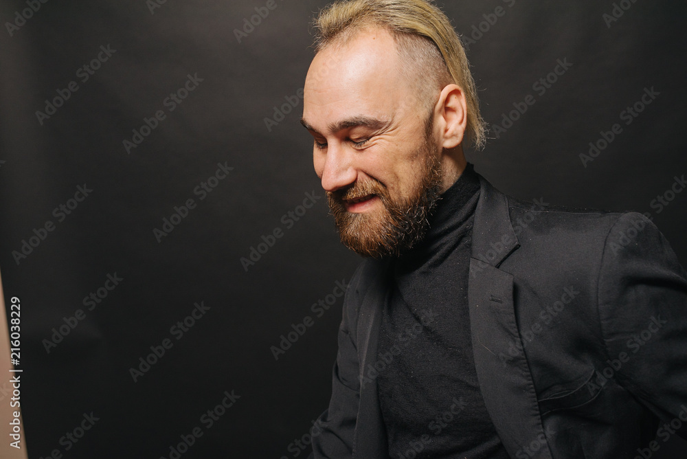 Obraz premium Elegancki przystojny mężczyzna w klasycznym garniturze pozuje w studio teatralnym.