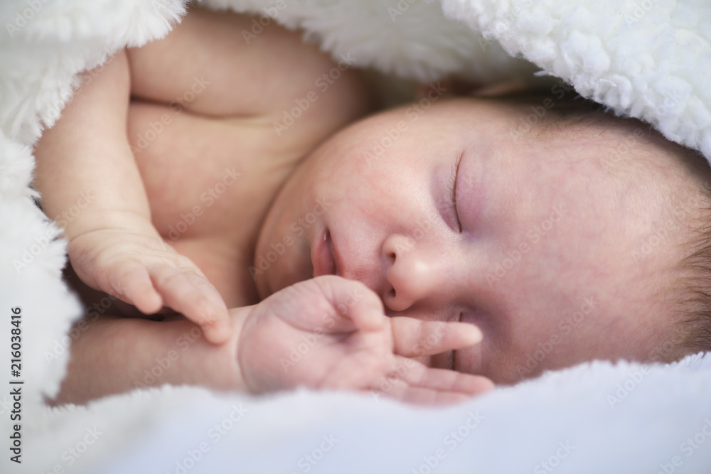 Newborn baby boy portrait on white carpet closeup. Motherhood and new life concept Newborn baby boy portrait on white carpet closeup. Motherhood and new life concept