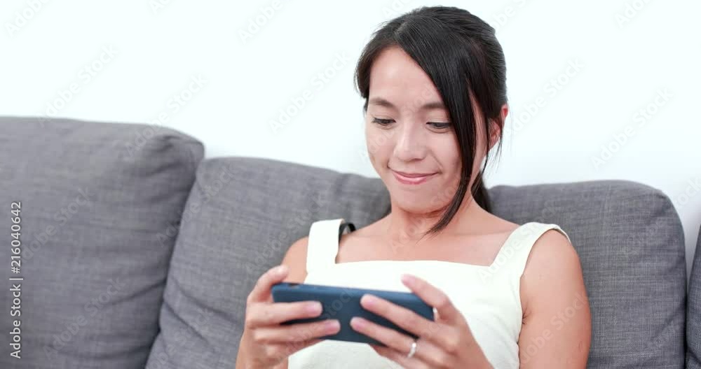 Woman play game on cellphone at home Woman play game on cellphone at home