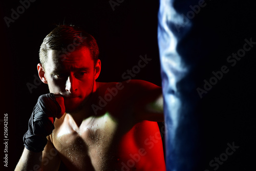 Training concept. Man boxer training in gym. Sportsman punch training bag. Training hard or go home © Volodymyr