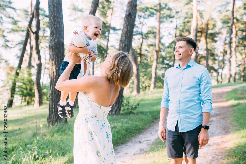 Fototapeta premium A cute family - mom, dad and son spend fun time in nature