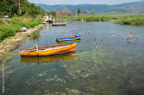 Fototapeta Naklejka Na Ścianę i Meble -  old colorful wooden fish boats on lake shore with reed, Lake Dojran, Macedonia