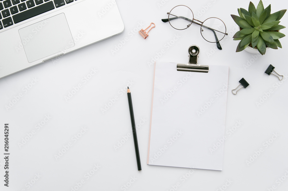 Home office workspace mockup with laptop, clipboard, green plant, notebook and eyeglasses, with copy space background. Flat lay, top view Home office workspace mockup with laptop, clipboard, green plant, notebook and eyeglasses, with copy space background. Flat lay, top view