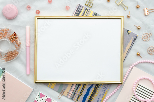 Flat lay with golden frame, and office supplies on white background. Top view mockup